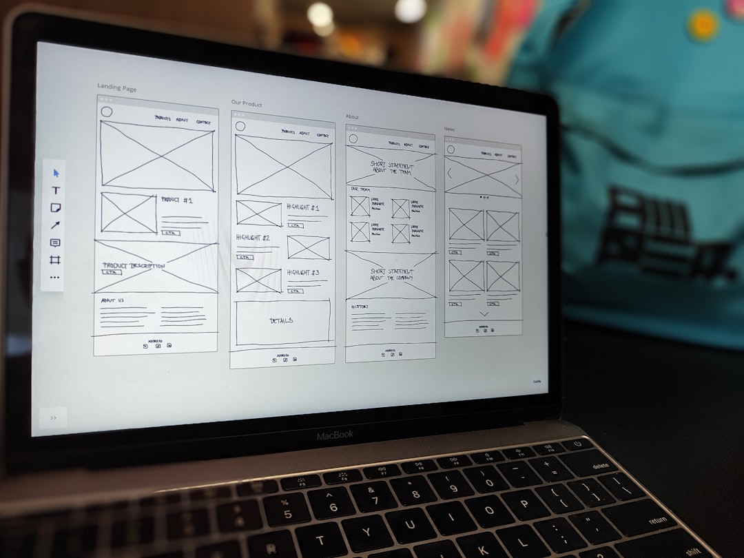 services-01 A website wireframe displayed on a MacBook screen sitting on an office desk.
